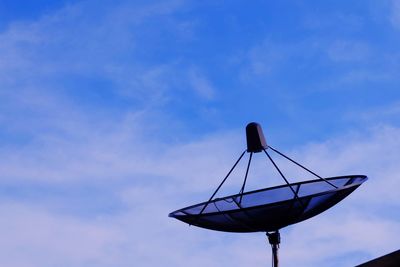 Low angle view of telephone pole against blue sky