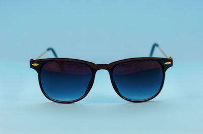 Close-up of sunglasses against blue background