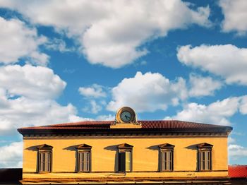 Low angle view of building against cloudy sky