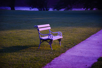 Empty bench on field in park