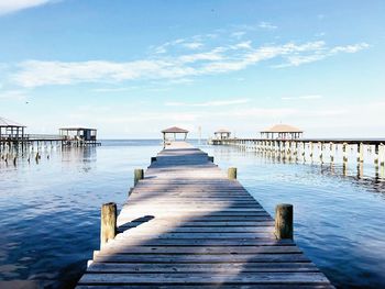 Wooden pier over sea against sky