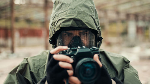 Military man with gas mask and camera photographs the destruction of the bomb