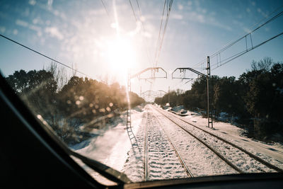 Railroad tracks against sky seen through glass