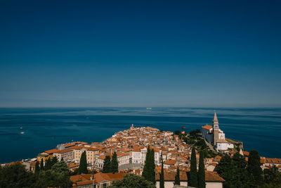 Aerial view of townscape against sea and sky