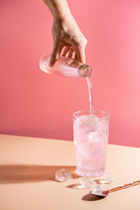 Close-up of hand pouring wine in glass