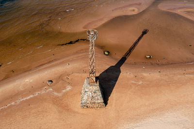 Abandoned ruins of kurmrags lighthouse on the baltic coast, aerial view, long shadow on a sunny day