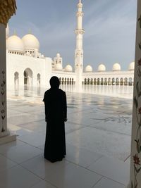 Rear view of woman standing in mosque