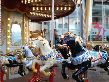 Rear view of carousel horses in amusement park