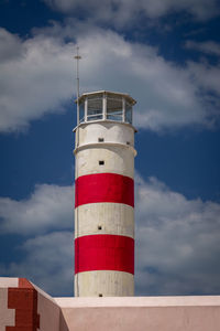 Lighthouse by sea against sky