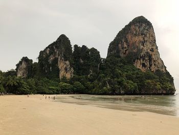 Rock formation on beach against sky