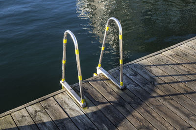 High angle view of railing on boardwalk by lake