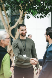 Portrait of smiling couple standing against trees