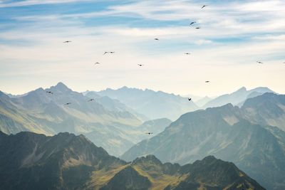 Tranquil view of birds flying above mountain ranges