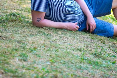 Midsection of man reclining on grass