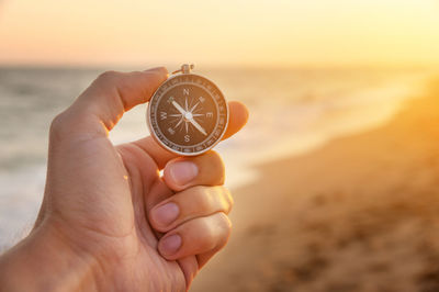 Cropped hand holding navigational compass