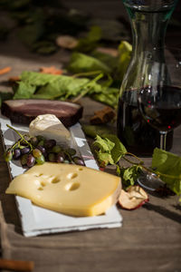 Close-up of red wine and cheese on wooden table