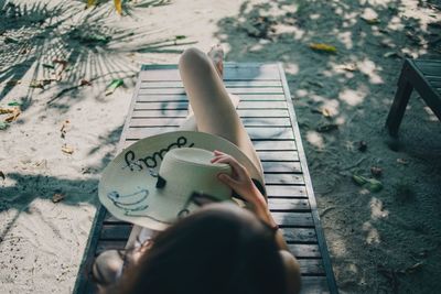 High angle view of woman hand on sand at beach