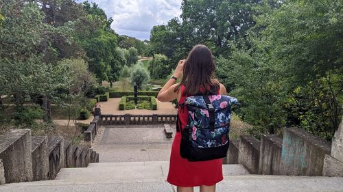 Rear view of woman standing against trees