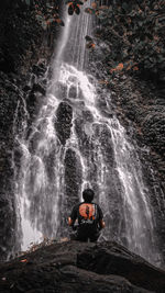 Man looking at waterfall