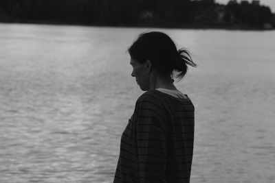 Side view of woman standing by lake