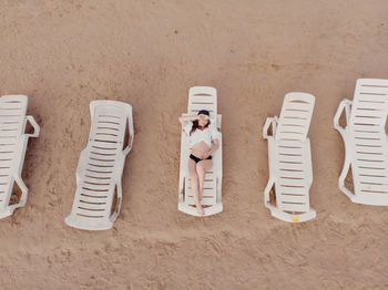 High angle view of people sitting on chair at beach