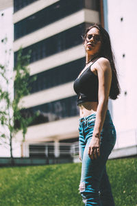 Portrait of woman standing against building in city