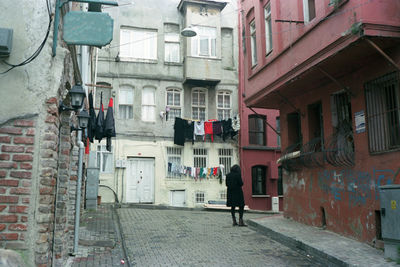 Rear view of woman standing on footpath