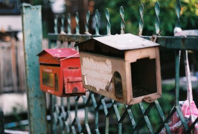 Close-up of old rusty metal post box on fence