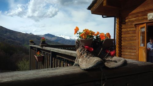 Low angle view of shoes sitting on railing against mountains