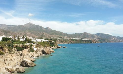 Scenic view of sea and mountains against sky