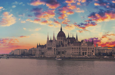 Buildings at waterfront during sunset