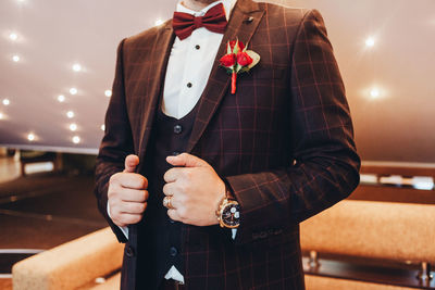 Midsection of groom holding blazer