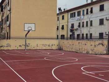 Basketball hoop by buildings in city