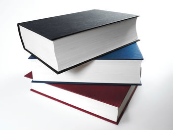 Close-up of books stacked against white background