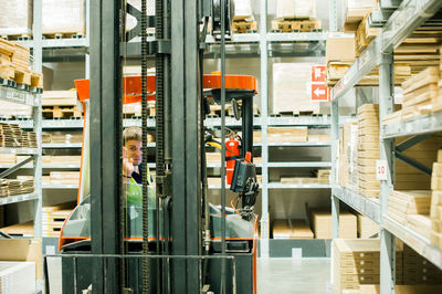 Worker driving forklift in factory