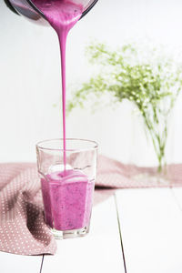 Close-up of hand pouring drink in glass