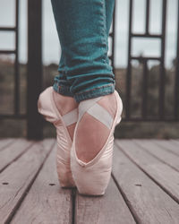 Low section of woman standing on hardwood floor