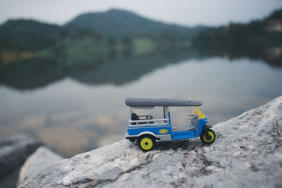 Close-up of toy car on rock by lake