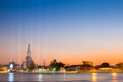 Illuminated buildings against sky at sunset