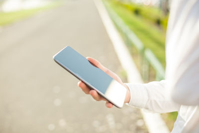 Midsection of person using mobile phone
