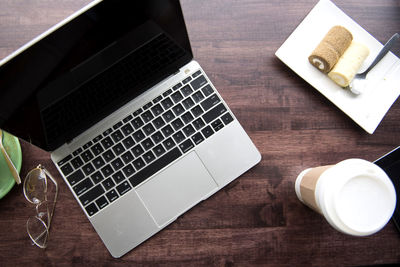 Directly above shot of laptop with desert and drink on table