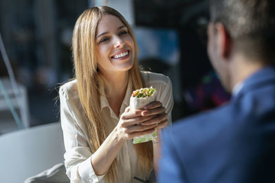 Smiling young woman holding ice cream