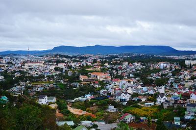 High angle shot of townscape against cloudy sky