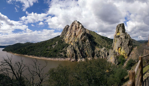 Panoramic view of mountain range against cloudy sky