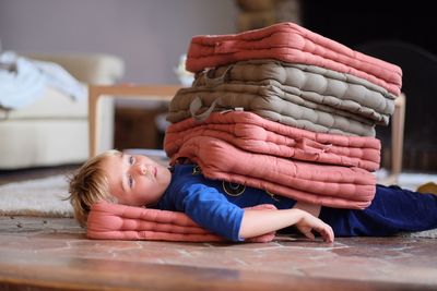 Stack of mattresses on boy