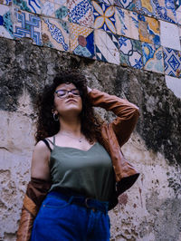 Young woman standing against sicilian majolica