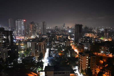 High angle view of illuminated buildings against sky at night