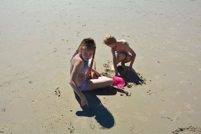 Rear view of friends enjoying on beach