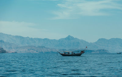 Boat sailing in sea against sky