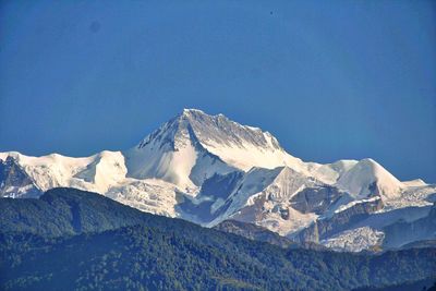 Scenic view of snow covered mountains against blue sky